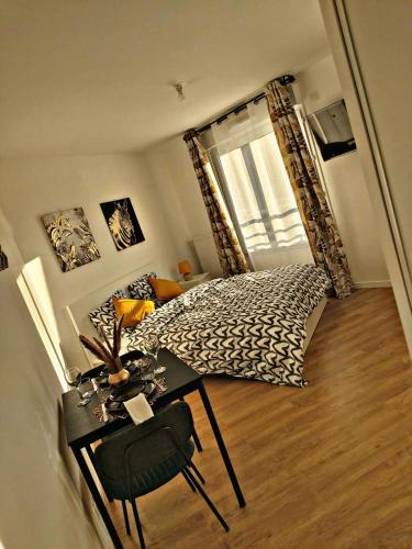 - une chambre avec un lit et une table dans l'établissement Loft climatisé parking gratuit 5min gare, à Le Plessis-Bouchard