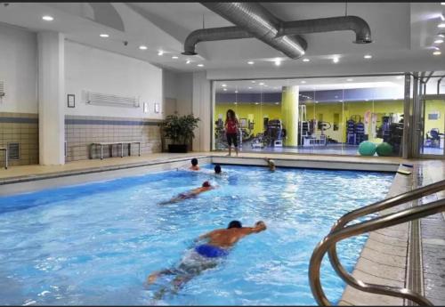 a group of people swimming in a swimming pool at Olimpic Village TH Sestriere apartments in Sestriere