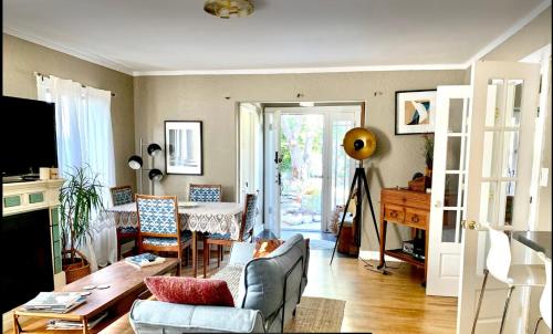 a living room with a couch and a table at Romantic cottage with amazing garden in Glendale