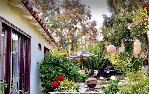 a garden with an umbrella and some plants and flowers at Romantic cottage with amazing garden in Glendale