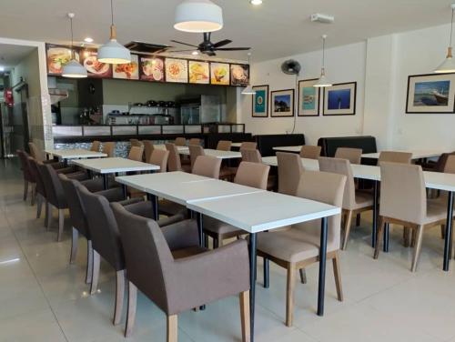 TY Hotel في كوالا ترغكانو: صف من الطاولات والكراسي في المطعم