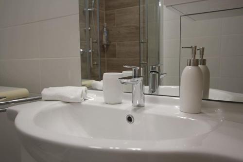 a bathroom with a white sink and a mirror at SuperB apartment with incredible view at the best location in Veszprém