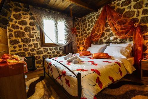 a bedroom with a bed in a room with stone walls at Katoikies Aiolos in Kato Trikala Korinthias