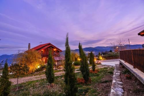 a house with a fence and trees in front of it at Katoikies Aiolos in Kato Trikala Korinthias
