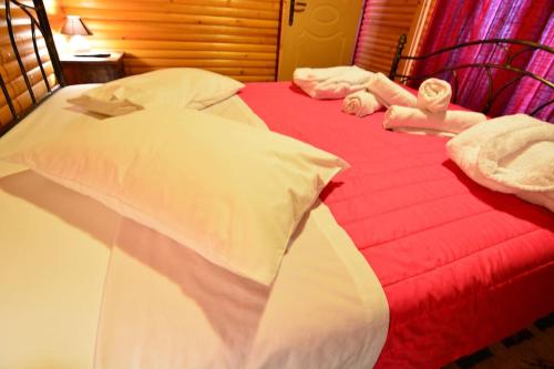a red and white bed with white towels on it at Katoikies Aiolos in Kato Trikala Korinthias