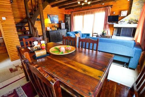 een eetkamer en een woonkamer met een houten tafel bij Katoikies Aiolos in Kato Trikala Korinthias