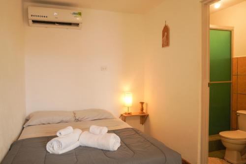 Un dormitorio con una cama con toallas. en Gala Apts, en Santa Teresa Beach