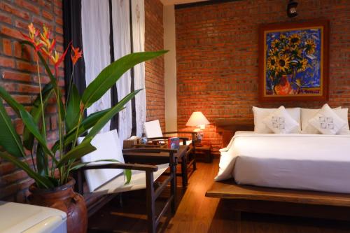 Una cama o camas en una habitación de Nghê Riverside Villa Hoi An