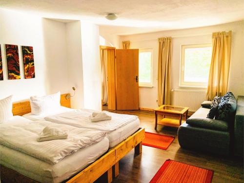 a hotel room with two beds and a couch at Landhotel Cafe Prälank in Neustrelitz