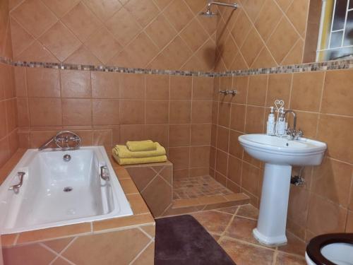 La salle de bains est pourvue d'une baignoire et d'un lavabo. dans l'établissement Pecan Nut Place, à Dalmada