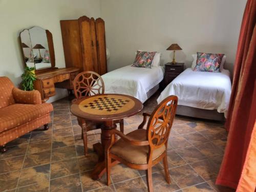 una camera con due letti e un tavolo e una sedia di Pecan Nut Place a Dalmada