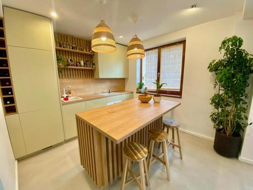 a kitchen with a wooden island with two stools at Sweet cozy Ultracentral in Craiova