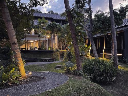 a house with a courtyard with palm trees at S.House168 in Chiang Mai
