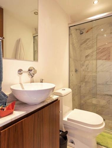 a bathroom with a sink and a toilet and a shower at Departamento mexicano en Polanco. Pool - gym - parking in Mexico City