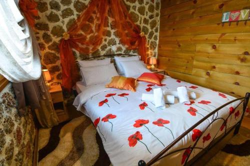 a bedroom with a bed with red flowers on it at Katoikies Aiolos in Kato Trikala Korinthias