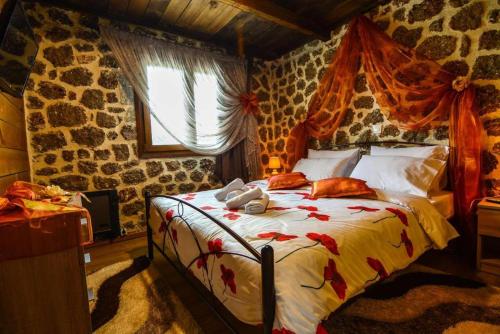 een slaapkamer met een bed in een kamer met stenen muren bij Katoikies Aiolos in Kato Trikala Korinthias