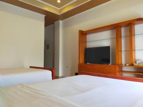 a bedroom with two beds and a flat screen tv at Nest Resort in Pagudpud