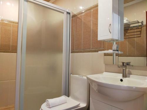 a bathroom with a toilet and a sink and a shower at Nest Resort in Pagudpud