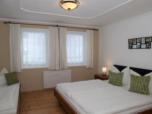 a bedroom with a large bed and two windows at Holiday flat Sonnau, Bramberg am Wildkogel in Bramberg am Wildkogel