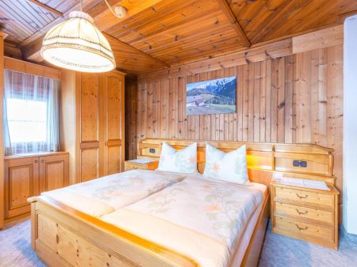 um quarto com uma cama grande num quarto de madeira em Cozy holiday home in Hochfilzen with mountain views em Hochfilzen
