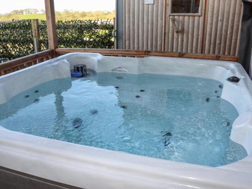 a jacuzzi tub with blue water in it at Pastures Barn in Leek