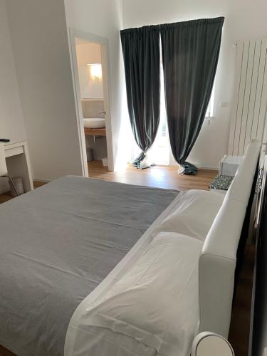 a bedroom with a bed and a window with curtains at Civico 28 in Pescara