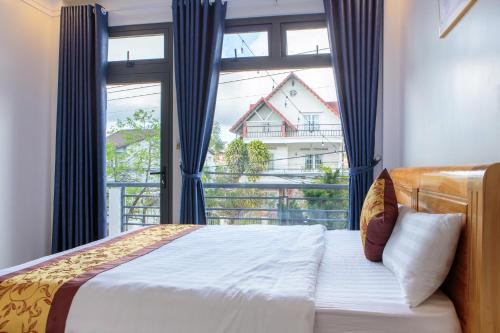 a bedroom with a bed and a large window at Trung Nghĩa Villa 21 in Da Lat
