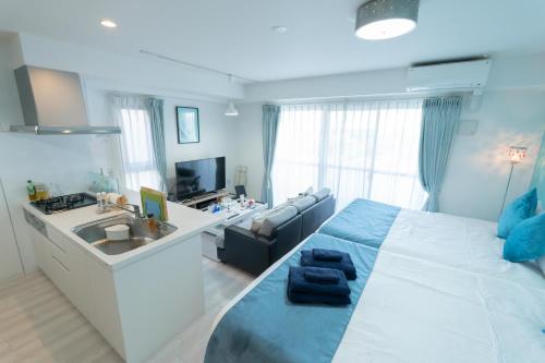 Japan Hinata Hotel 池下駅徒歩2分 1LDK 50平米 8名 في ناغويا: غرفة نوم بسرير ومغسلة وأريكة