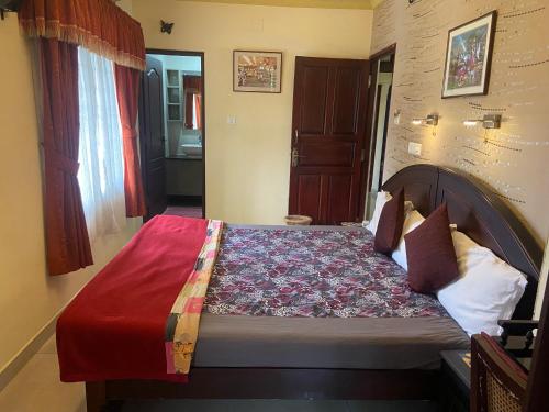 a bedroom with a bed with a red blanket at Sajhome Fortkochi, Kochi, Kerala, inda in Cochin