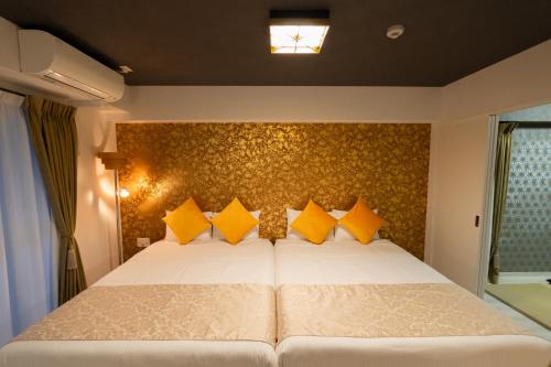 a bedroom with a large white bed with yellow pillows at Japan Hinata Hotel 池下駅 1番出口 徒歩2分 1LDK 50平米 8名 in Nagoya