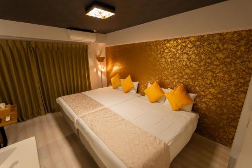 a bedroom with a large bed with yellow pillows at Japan Hinata Hotel 池下駅 1番出口 徒歩2分 1LDK 50平米 8名 in Nagoya