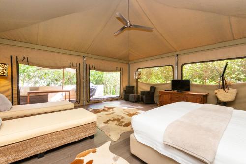 1 dormitorio con 2 camas y TV. en The Billi Resort en Broome