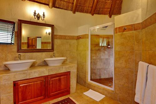 a bathroom with two sinks and a shower at Royal Morubisi Founder's Lodge in Kaingo Private Game Reserve