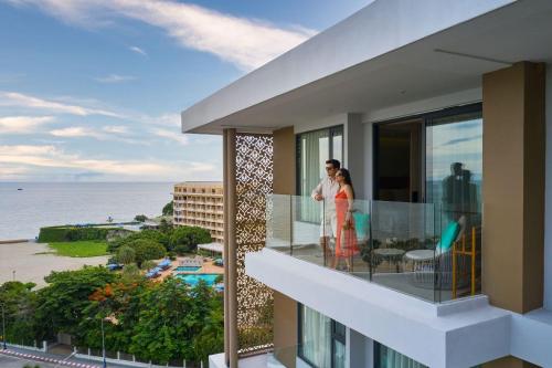 a couple standing on a balcony looking out at the ocean at Amari Pattaya in Pattaya Central