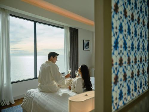 a man and woman sitting on a bed in a hotel room at Amari Pattaya in Pattaya Central