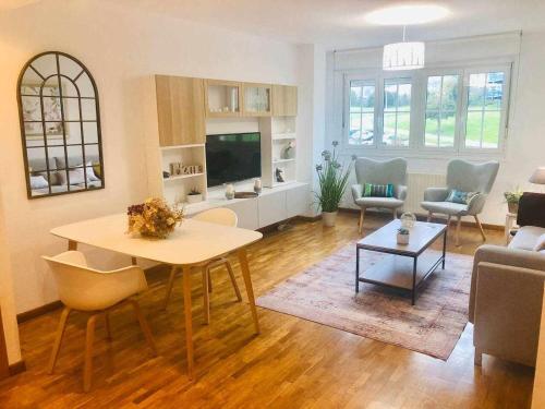uma sala de estar com uma mesa, um sofá e uma televisão em Avenida Apartamento em Oviedo