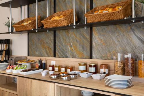 a counter with plates of food and baskets of bread at Best Western Hotel & SPA Coeur De Cassis in Cassis