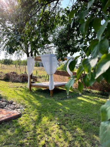 two white curtains on a bench in the grass at Smaragd in Doba