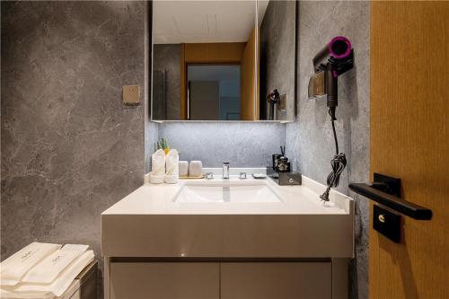 a bathroom with a white sink and a mirror at Cres Asia Residence in Chengdu
