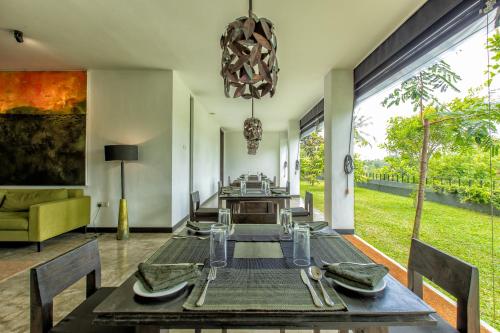 a dining room with a table and a couch at Splendour Residence in Balapitiya