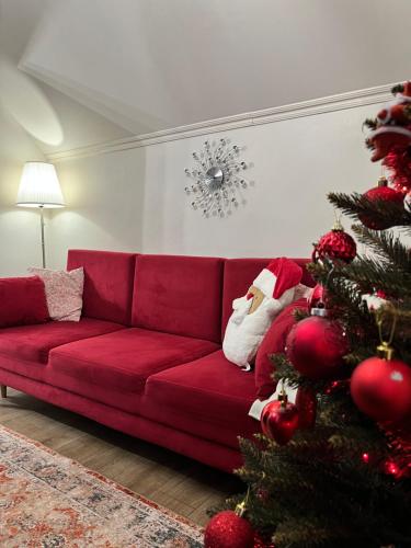 a living room with a red couch and a christmas tree at Rubin in Doba