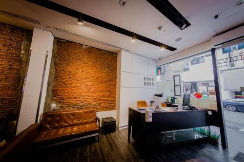 a salon with a leather chair and a desk at D'Nova Hotel Bugis in Singapore