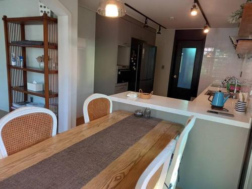 a kitchen with a table and chairs and a counter at Sogobe Jeju House in Jeju