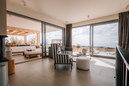 - un salon avec de grandes baies vitrées et un canapé dans l'établissement Luxury villas on Island Pag - Plant Villas Novalja, à Novalja