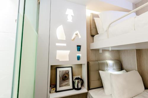 a room with two bunk beds and a mirror at D'Nova Hotel Bugis in Singapore