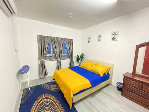 Un dormitorio con una cama amarilla y azul y un espejo en Homestay Kuala Terengganu Affan01 Dekat Pantai Batu Buruk en Kuala Terengganu