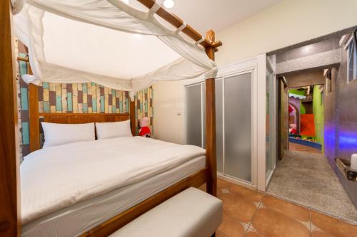 ein Schlafzimmer mit einem Himmelbett in der Unterkunft Rococo Homestay in Altstadt von Hengchun