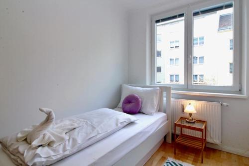 una camera bianca con un letto con un cuscino viola di Central Vienna Charm - Comfortable 3-BR Stay a Vienna