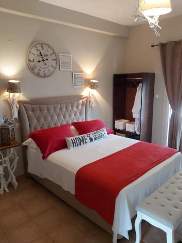 1 dormitorio con 1 cama grande y reloj en la pared en Machi Rooms, en Patitiri