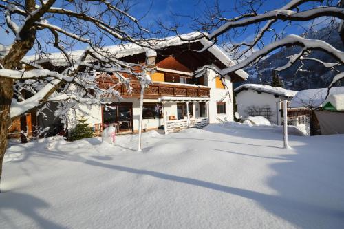 a house with snow on the ground in front of it at Ferienwohnung Glusavinahüsle in Vandans